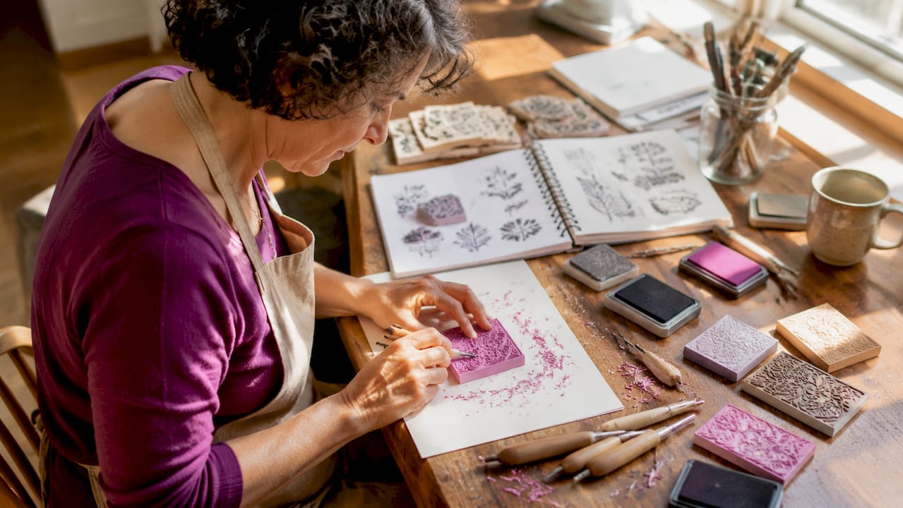 Woman hand-carving a collectible stamp