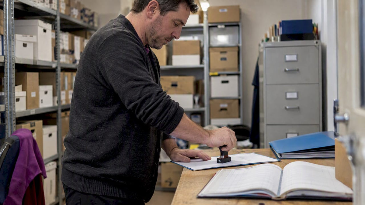 Administrator using a stamp beside a register