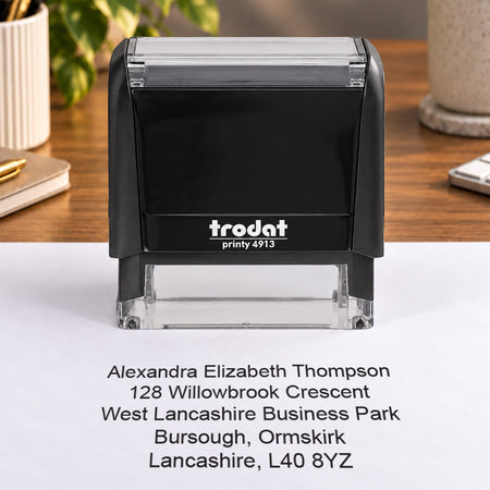 Trodat Printy 4913 on a desk beside a sample Alexandra Elizabeth Thompson address impression