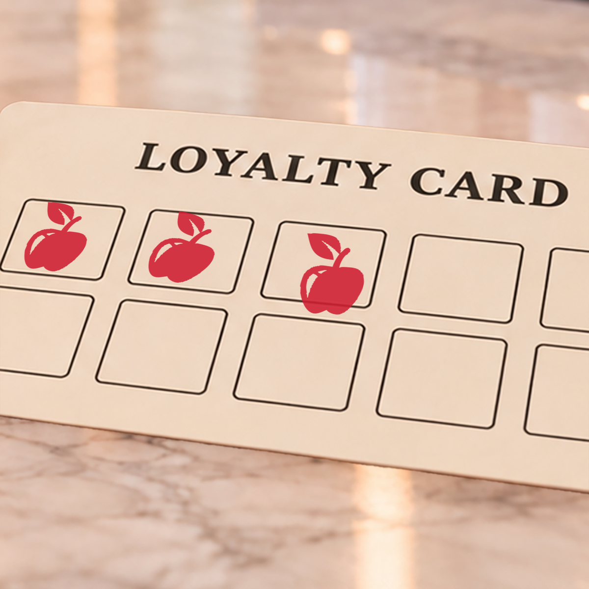 Close-up of red apple impressions on an example loyalty card