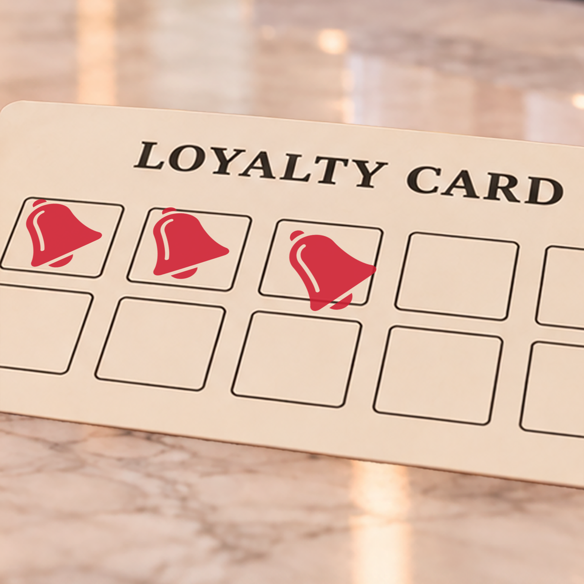 Close-up of red bell impressions on an example loyalty card