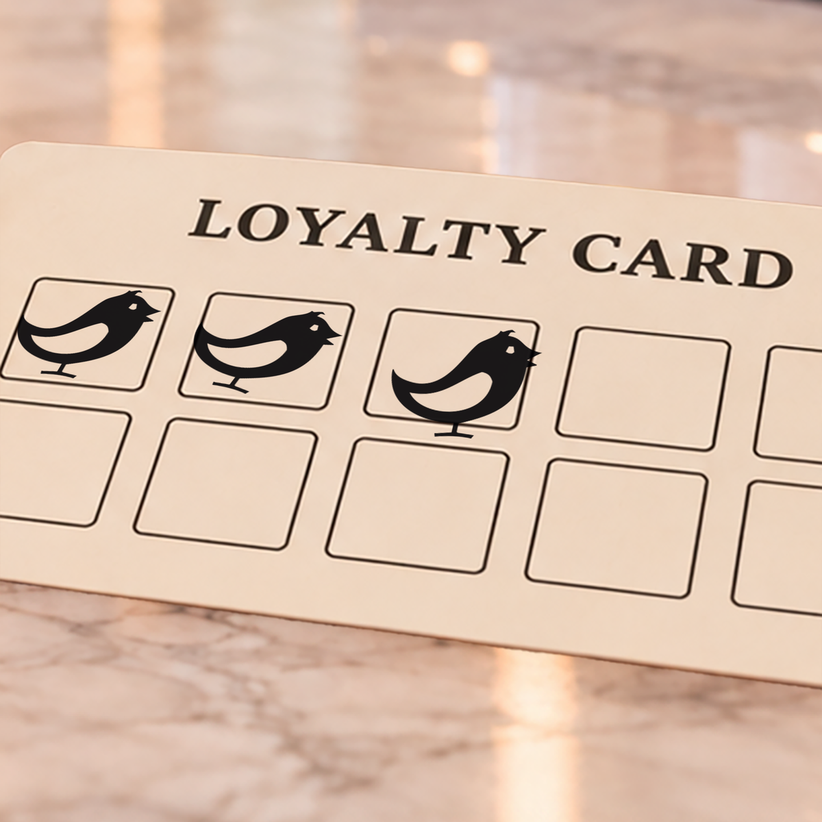 Close-up of black bird impressions on an example loyalty card
