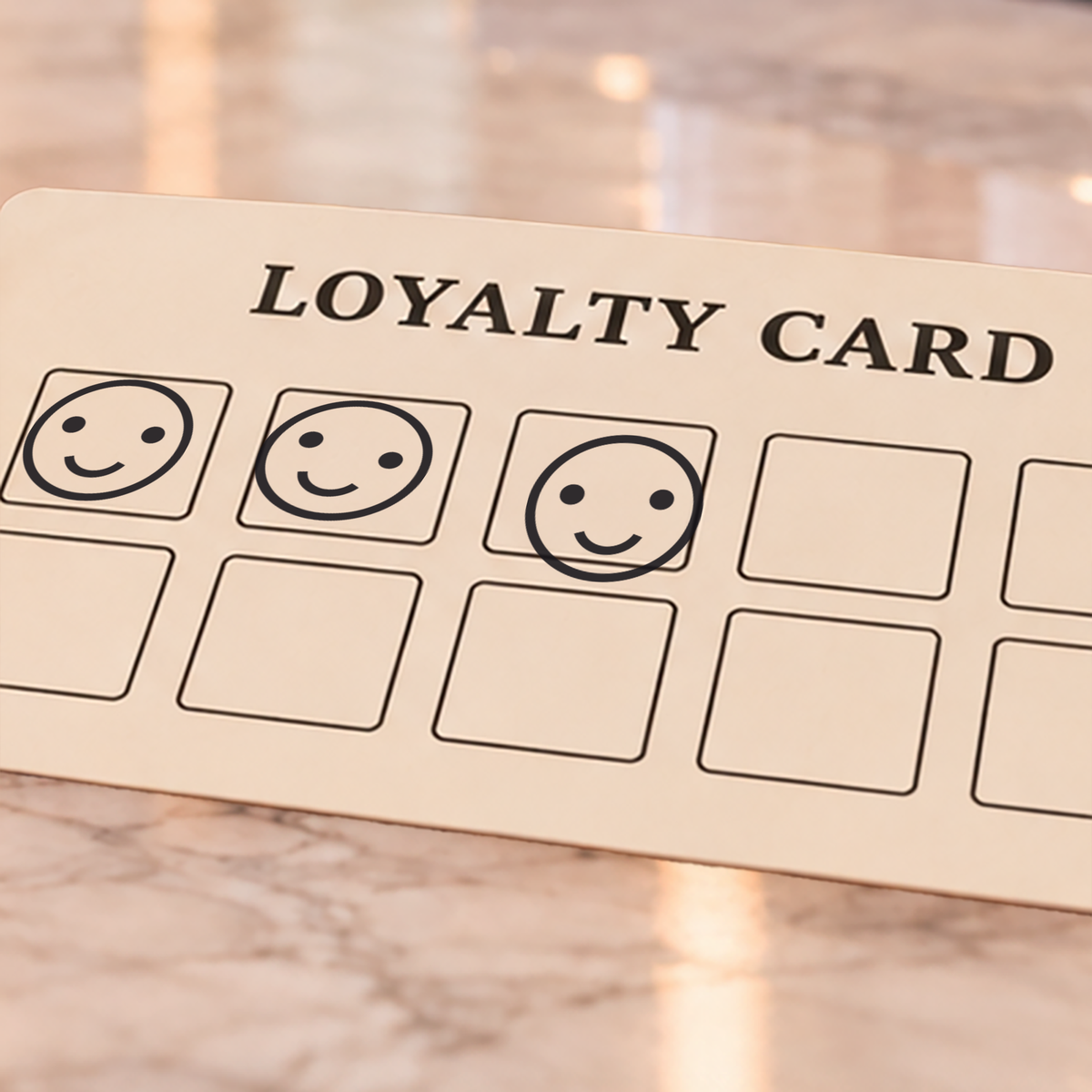 Example loyalty card with three smiley-face marks and empty reward boxes