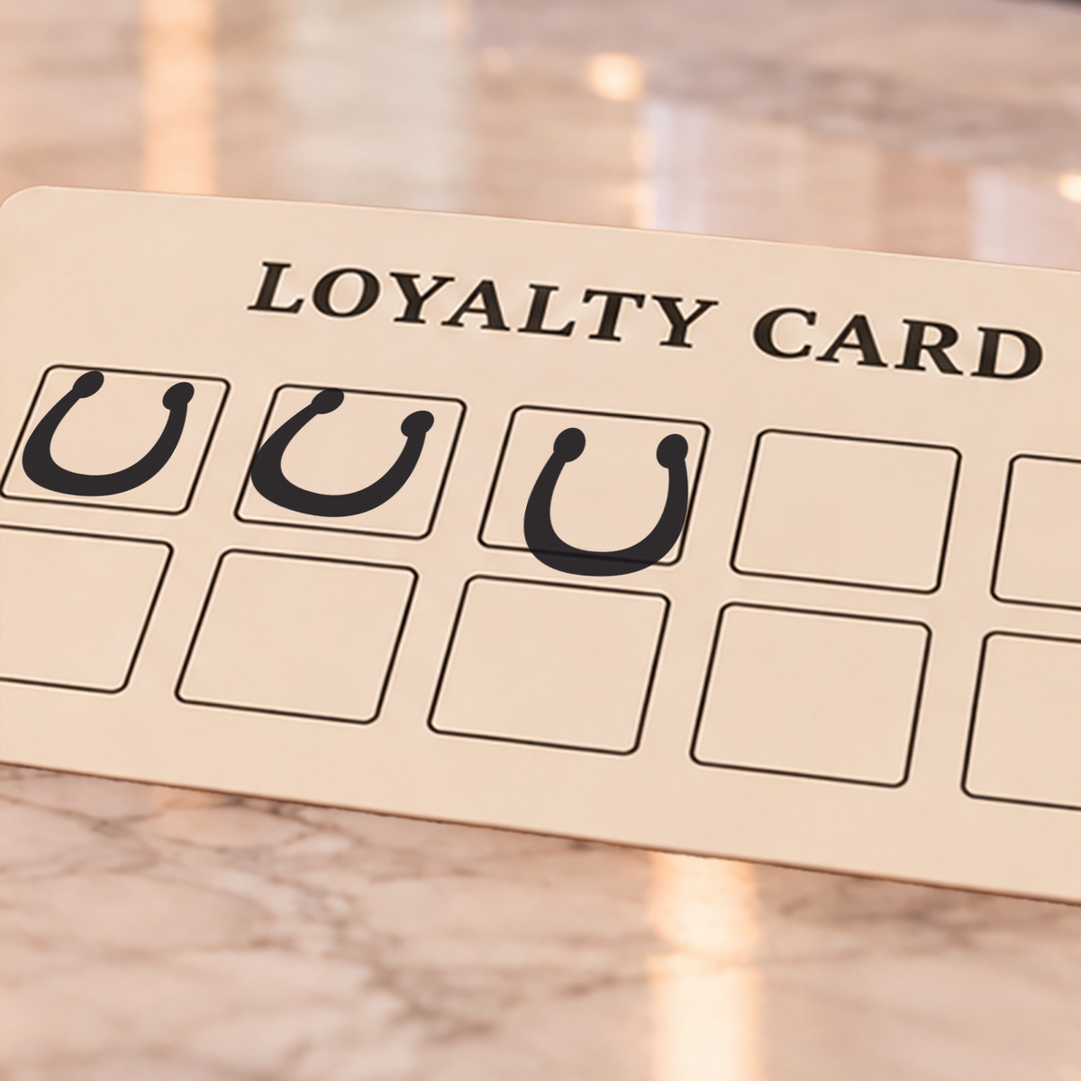 Close-up of black horseshoe impressions on an example loyalty card