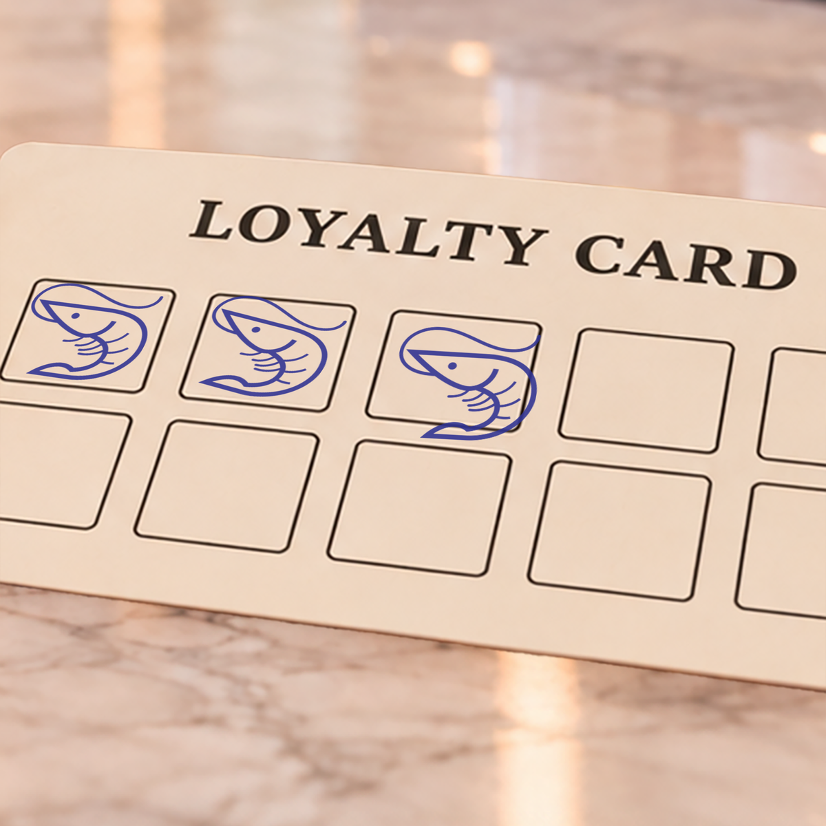 Close-up of blue prawn impressions on an example loyalty card