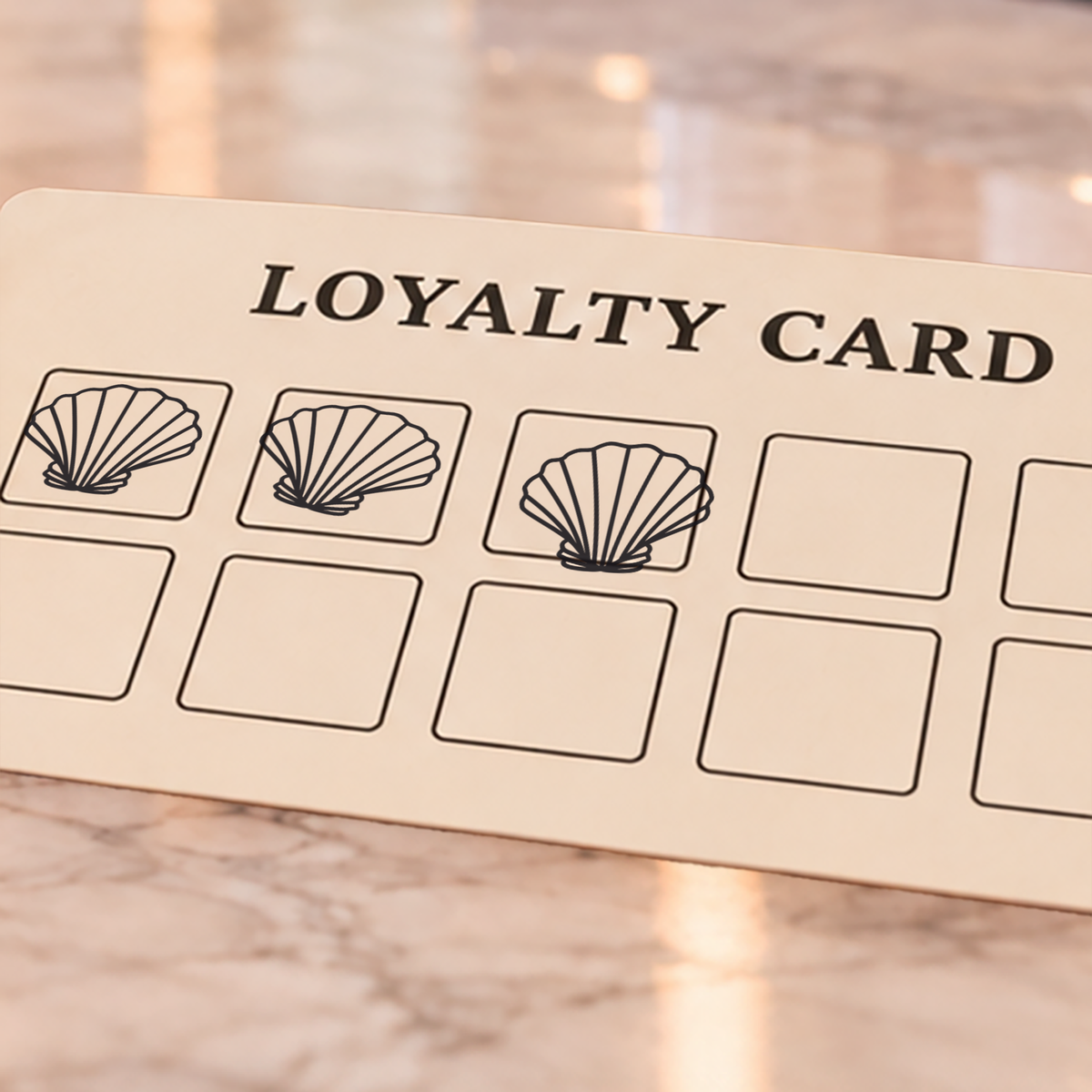 Close-up of black sea shell impressions on an example loyalty card