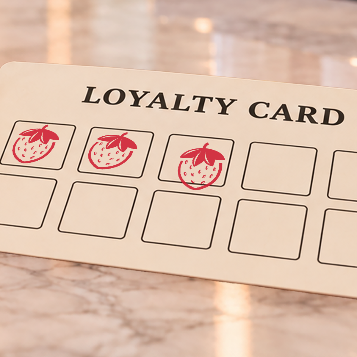 Close-up of red strawberry impressions on an example loyalty card