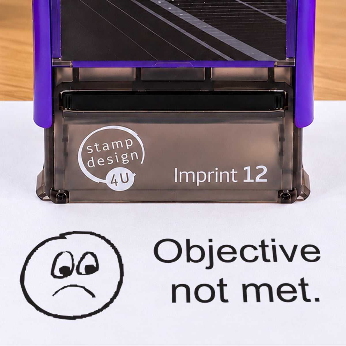 Objective Not Met teacher stamp: close-up of the pictured Imprint 12 casing and black sad-face impression