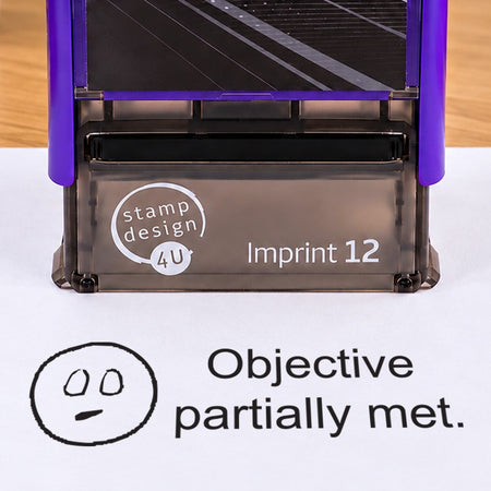 Objective Partially Met teacher stamp: close-up of the pictured Imprint 12 casing and black neutral-face impression