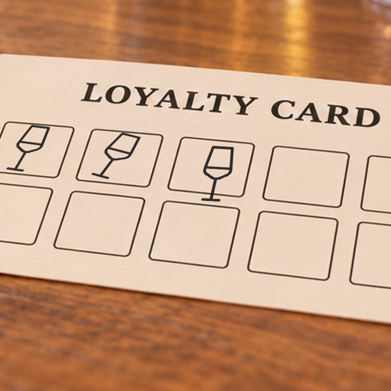 Close-up of black wine glass impressions on an example loyalty card
