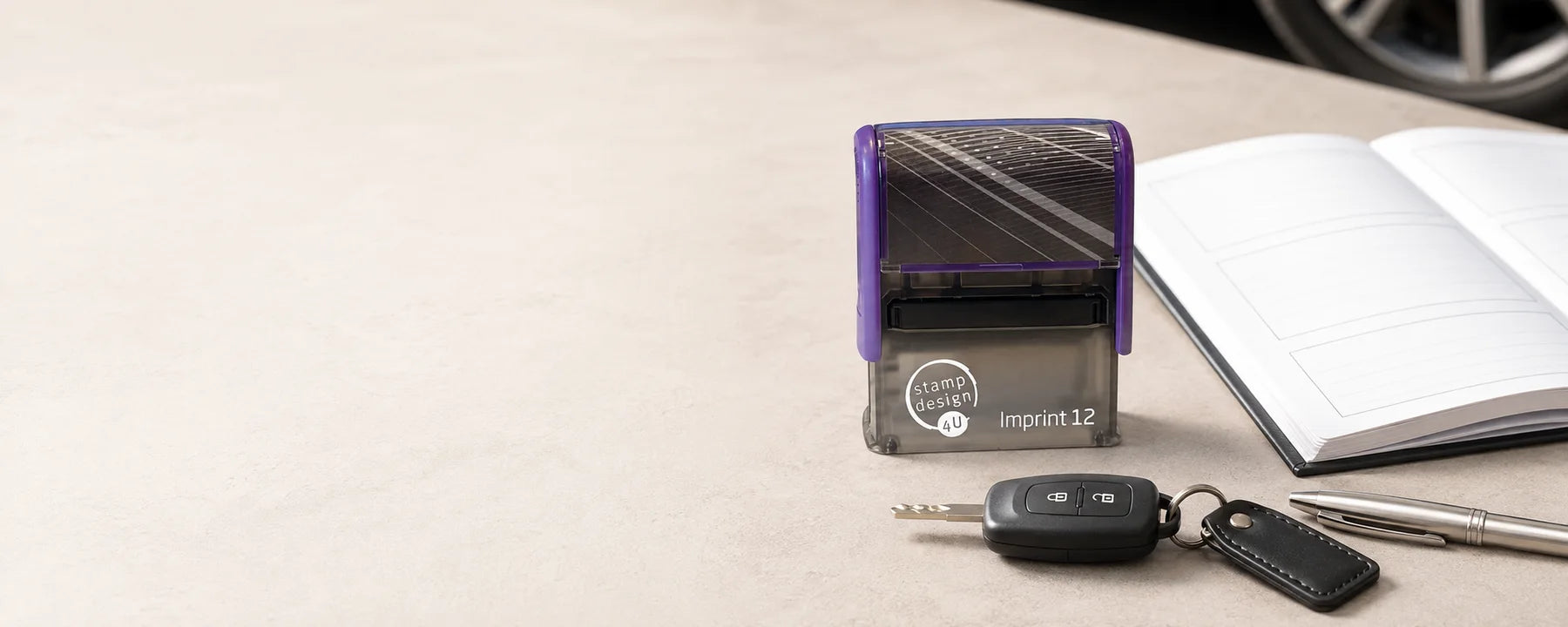 Stamp Design 4U Imprint 12 self-inking stamp with a blank vehicle service book, car key and pen